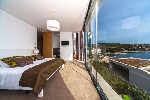 a bedroom with a bed and a view of the water at Golden Rays Luxury Villas & Apartments in Primošten