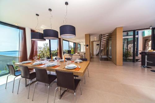 a dining room with a large wooden table and chairs at Golden Rays Luxury Villas & Apartments in Primošten