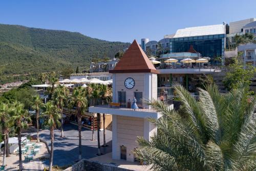 a building with a clock tower next to a resort at Duja Bodrum in Torba
