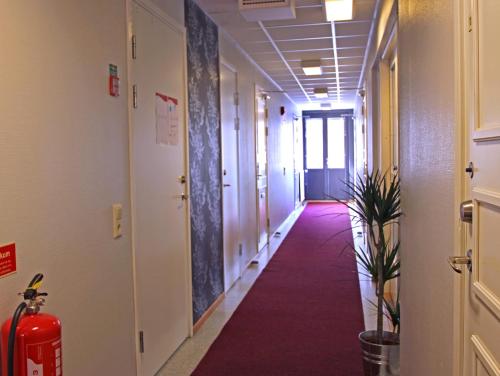an empty hallway with a red carpet in an office building at Karlshamn Vandrarhem och Hotell in Karlshamn