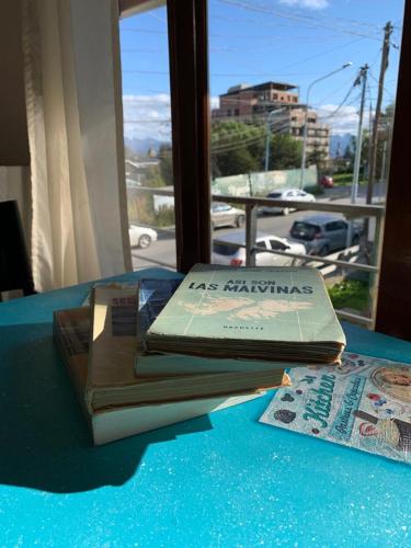 un libro sentado en una mesa junto a un periódico en Aunaisin-Paz Centro-Vintage en Ushuaia