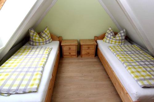 2 camas individuais num pequeno quarto no sótão em Ferienhaus Schild em Elsterheide