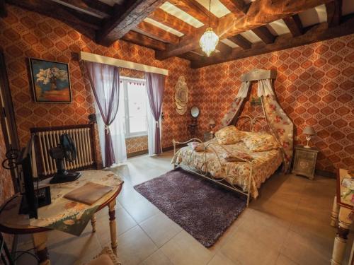ein Schlafzimmer mit einem Bett und einem Tisch darin in der Unterkunft Domaine le Bourdet in Saint-Sauveur-de-Cruzières