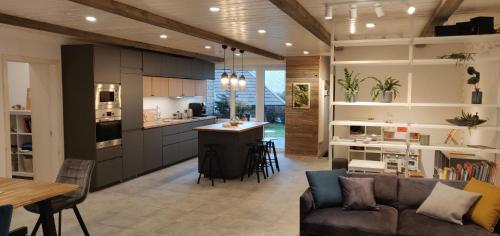 een woonkamer en keuken met een bank en een tafel bij Family house in Druskininkai