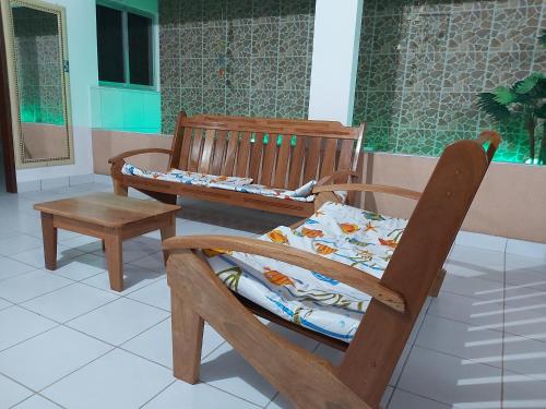 een houten schommelstoel met een kussen en een krukje bij Maragogi - Casa com piscina in Maragogi