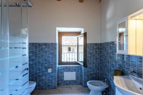 La salle de bains est pourvue de toilettes, d'un lavabo et d'une fenêtre. dans l'établissement Ap. Artù - Lago di Garda, à Tremosine