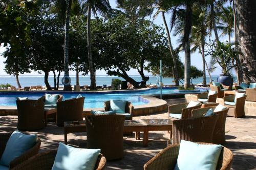 eine Terrasse des Resorts mit Stühlen und einem Pool in der Unterkunft Ocean Village Club (Adults Only) in Diani Beach