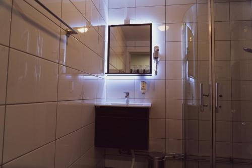a bathroom with a sink and a mirror at Liljeholmens Stadshotell in Stockholm