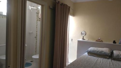 1 dormitorio con 1 cama y baño con ducha en APARTAMENTO TEMPORADA EM PORTO SEGURO, en Porto Seguro