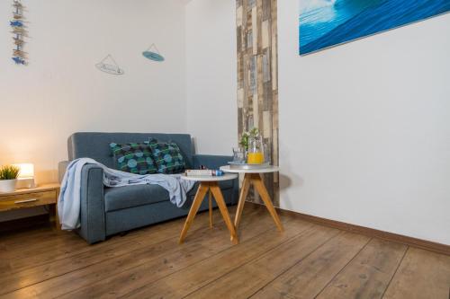 a living room with a blue couch and a table at Ein Bett im Norden in Fehmarn