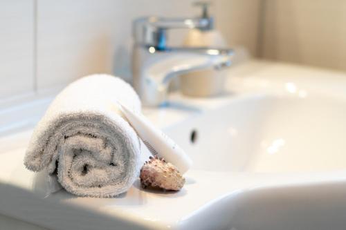 a white towel sitting on a bathroom sink at Ein Bett im Norden in Fehmarn