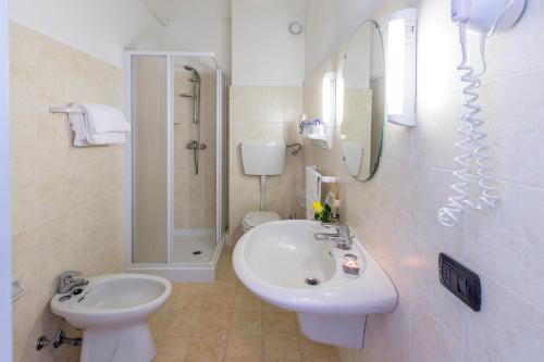 a bathroom with a sink and a toilet and a mirror at Grand Hotel Excelsior in San Benedetto del Tronto
