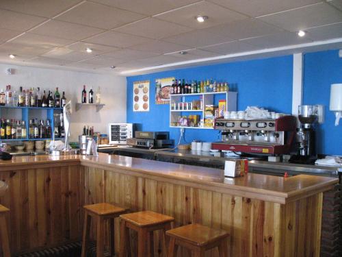 a bar in a restaurant with blue walls and stools at Apartamentos Montreal in Sierra Nevada