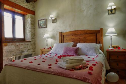 a bedroom with a large bed with red roses on it at Mas Tulsà Casa Rural Girona in Riudellots de la Creu