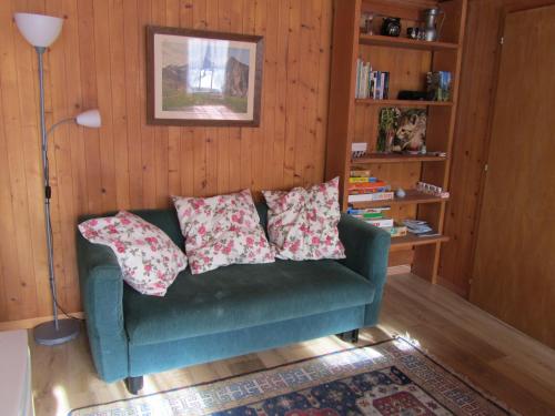 a living room with a green couch with pillows on it at Gutenbrunnenstrasse 94 in Lenk