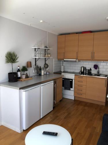 a kitchen with white appliances and wooden cabinets at Fin lägenhet med balkong centralt o bra läge in Käringön