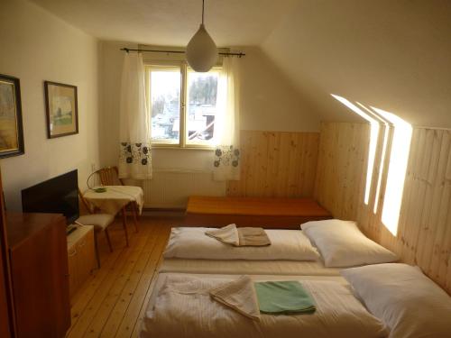 een slaapkamer met twee bedden, een bureau en een raam bij Villa Ester in Tatranská Lomnica