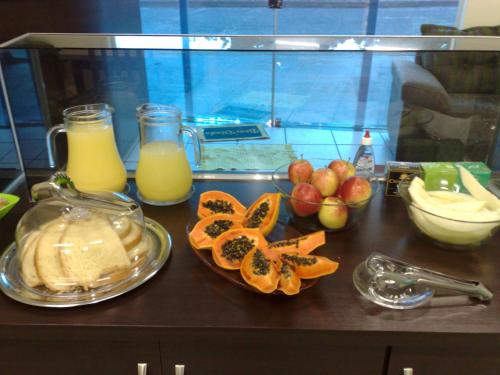 un mostrador con naranjas y otras frutas y zumo de naranja en Araguaia Hotel, en Bom Jesus