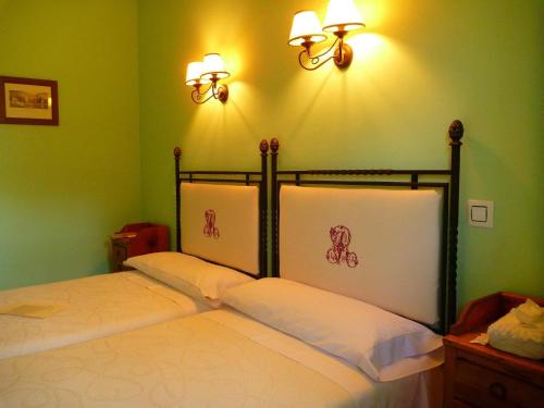 a bed in a room with two lights on the wall at Casa Rural El Roblon in Sartajada