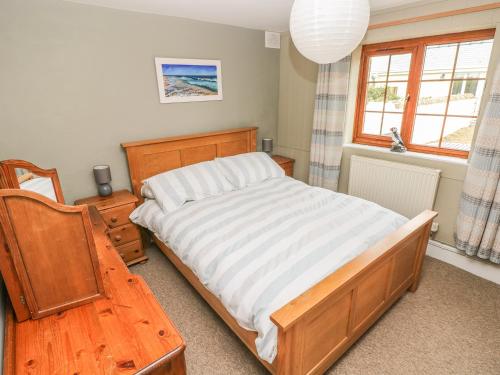 a bedroom with a bed and a table and a window at Foxglove Cottage in Haverfordwest