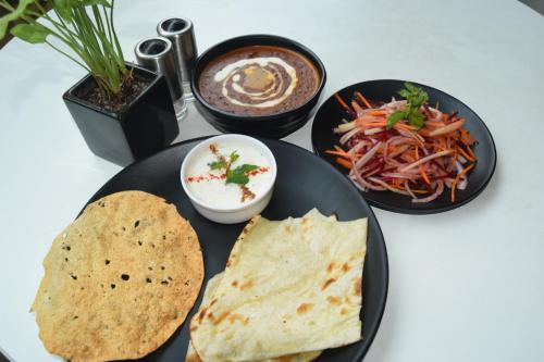 a table with three plates of food on a table at Ginger Lucknow in Lucknow