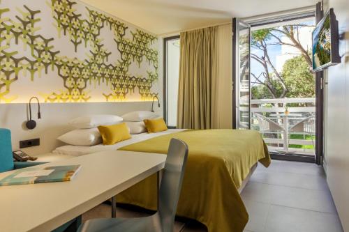 a hotel room with two beds and a desk at Bluesun Mala Berulia in Brela