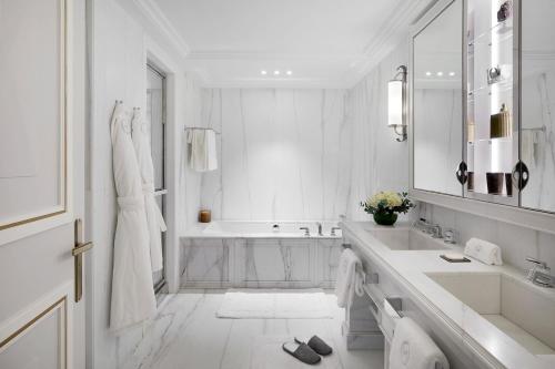 a white bathroom with a sink and a tub at Maison Villeroy in Paris