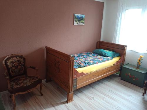 1 dormitorio con 1 cama, 1 silla y 1 ventana en B&B Im Bitzi, en Zuzwil