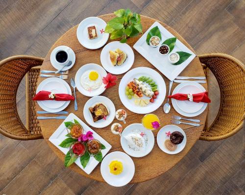 a wooden table with plates of food on it at Villa Pantai Milagres Exclusive Hotel in São Miguel dos Milagres