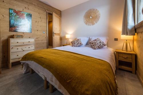 een slaapkamer met een groot bed met twee kussens bij ODYSSEE CRC04 - Charmant appartement sur les pistes in La Toussuire