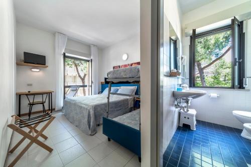 a bathroom with a bedroom with a bunk bed and a sink at Hotel Morotti in Misano Adriatico