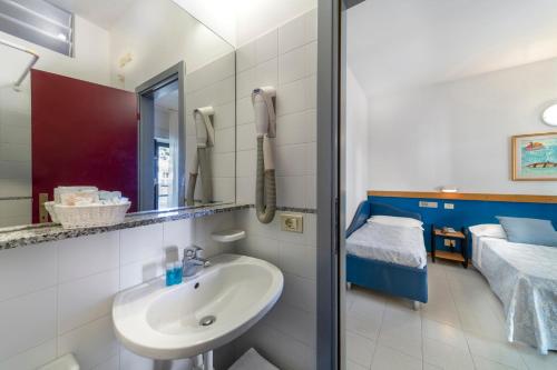 a bathroom with a sink and a bed at Hotel Morotti in Misano Adriatico