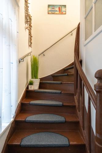 a staircase in a house with wooden floors and a stair mat at Ein Bett im Norden in Fehmarn