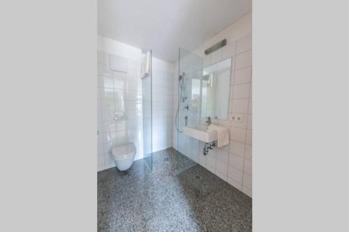 a white bathroom with a sink and a toilet at Ora et labora in Malles Venosta