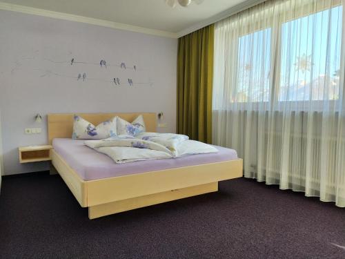 ein Schlafzimmer mit einem Bett und einem großen Fenster in der Unterkunft Haus Mitti in Heinfels