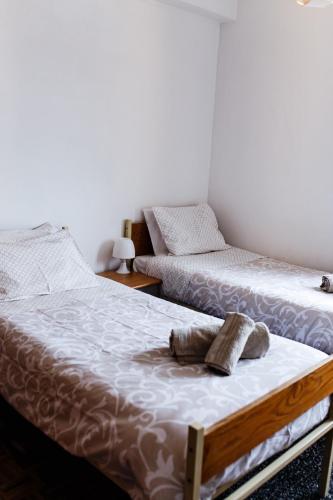 two beds sitting next to each other in a room at Aveiro City Center in Aveiro
