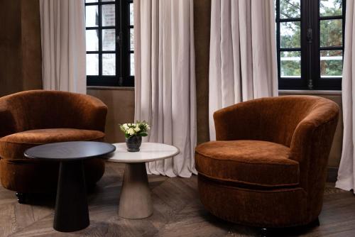 two chairs and a table in a room at Hôtel Saint-Delis - La Maison du Peintre - Relais & Châteaux in Honfleur