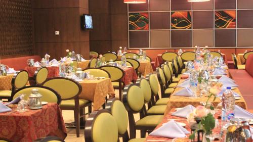 a row of tables in a banquet hall at Crowne Plaza Madinah by IHG in Al Madinah