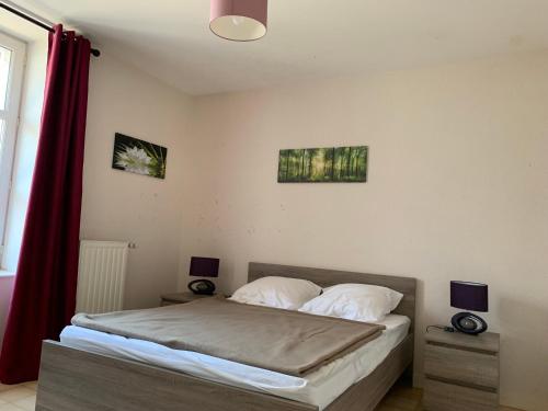 a bedroom with a bed with two pictures on the wall at Auberge de la Tour in Freycenet-la-Tour