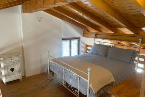 a bedroom with a bed in a room with wooden ceilings at Country Corner Lago Maggiore in Divignano