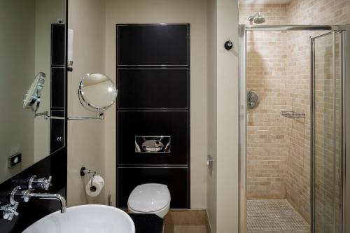 y baño con ducha, aseo y lavamanos. en Bowood Hotel, Spa, and Golf Resort en Chippenham
