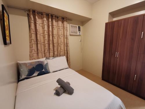 a bedroom with a bed and a brown cabinet at Avida Davao by davaobnb & Lemonique Homes in Davao City