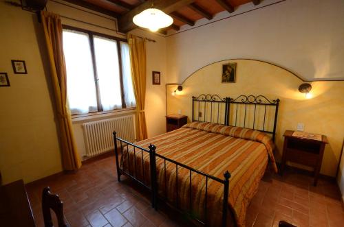 um quarto com uma cama e uma grande janela em Agriturismo La Casella em Castelfranco di Sopra