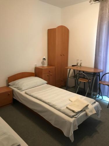 a bedroom with a bed and a desk and a table at PENZION ANIKO DIAKOVCE-ŠAĽA in Diakovce