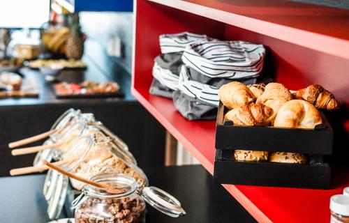 une étagère avec plein de pains et de viennoiseries dans l'établissement Aparthotel Panorama Living Dolomites, à Maranza