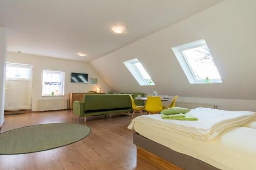 a bedroom with a bed and a desk and windows at Ein Bett im Norden in Fehmarn