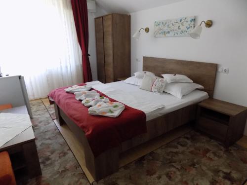 een slaapkamer met een bed met twee gerechten erop bij Pension Eden in Băile Herculane