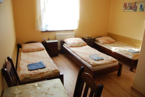 Habitación con 3 camas, mesa y ventana en Motel Kochlice en Kochlice