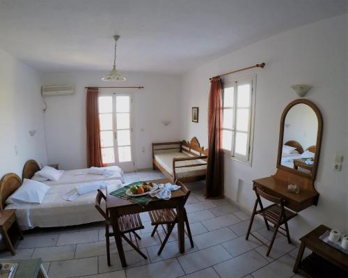 a bedroom with a bed and a table and a mirror at Birbas Hotel in Agia Anna Naxos