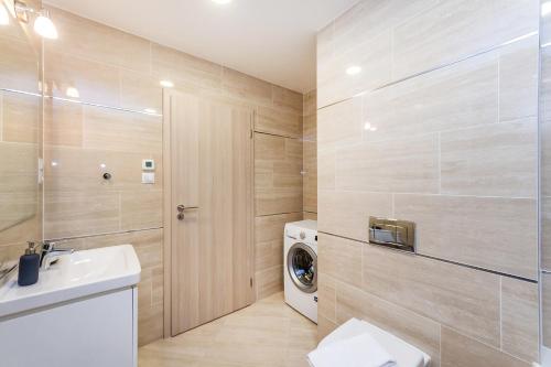 a bathroom with a washing machine and a washer and dryer at REZIDENCE U VLTAVY in Prague